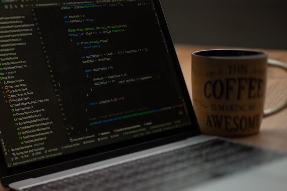 Photograph of a computer screen displaying a close-up of colorful code on a dark background, featuring syntax highlighting with various keywords and symbols in red, green, yellow, blue, and white. The